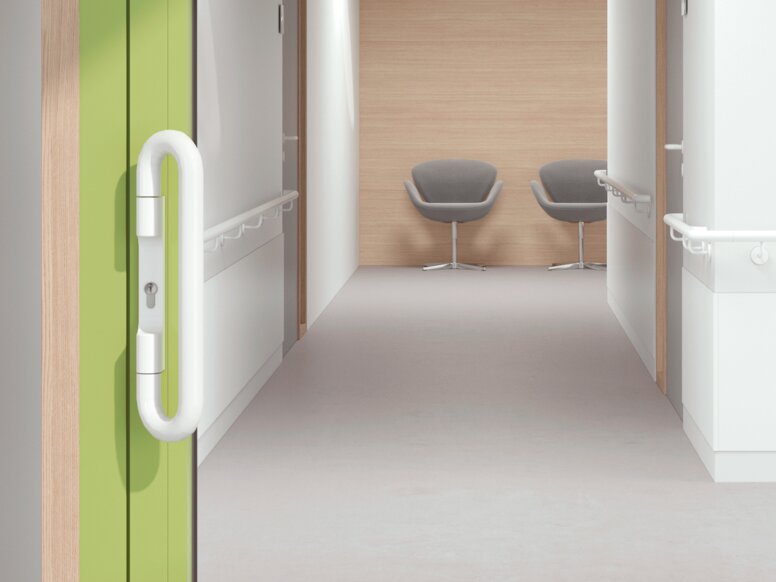 Verglaste Krankenhaustür mit grünem Rahmen ausgestattet mit HEWI Drückergriff in Signalweiß aus Polyamid