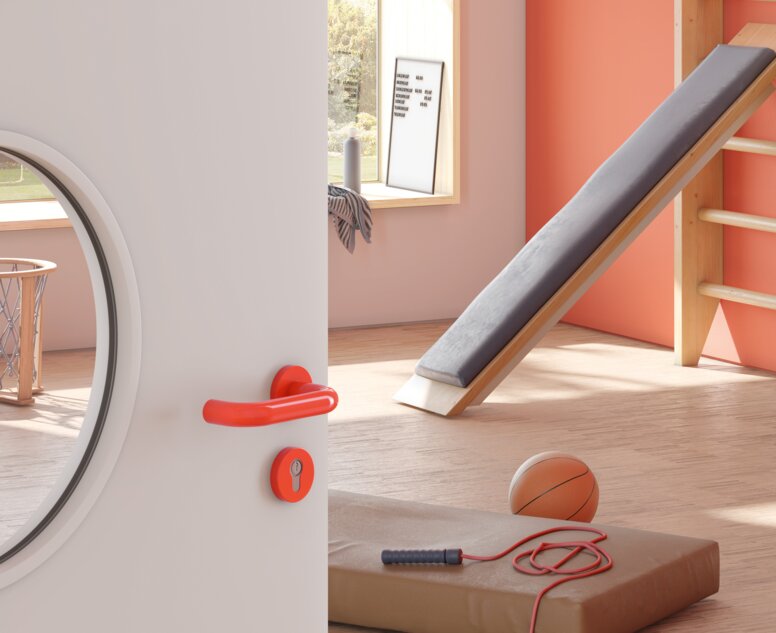 Tür zu einem Sportraum eines Kindergartens ausgestattet mit HEWI Türdrücker 111 in Orange aus Polyamid