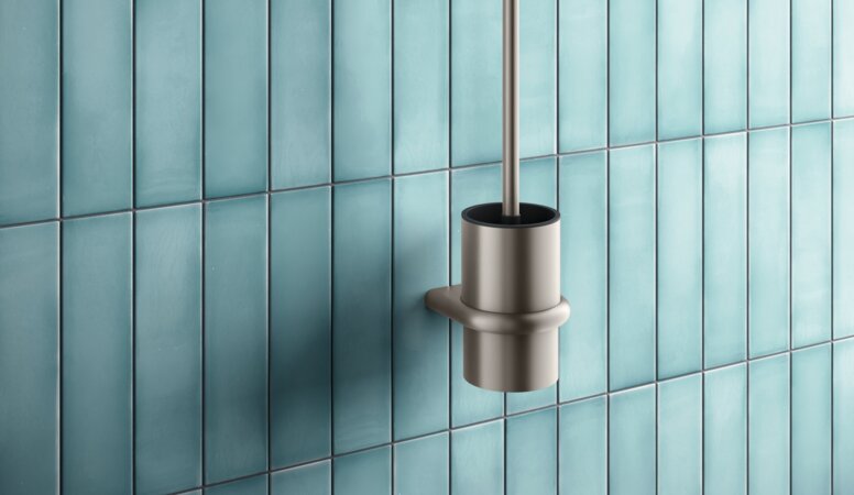 Toilettenbürste und seitlicher WC-Papierhalter mit bronzefarbener PVD-Beschichtung vor blauen Fliesen