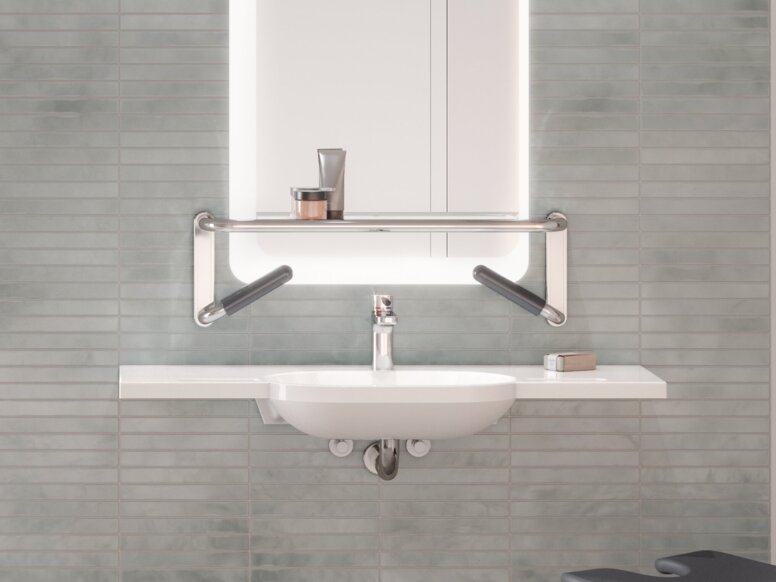 HEWI Serie 802 LifeSystem Interieur Duschsitz und Handlauf an einer Brausehalterstange in einem Duschbereich, daneben ein an einer gefliesten Wand montierter Waschtisch
