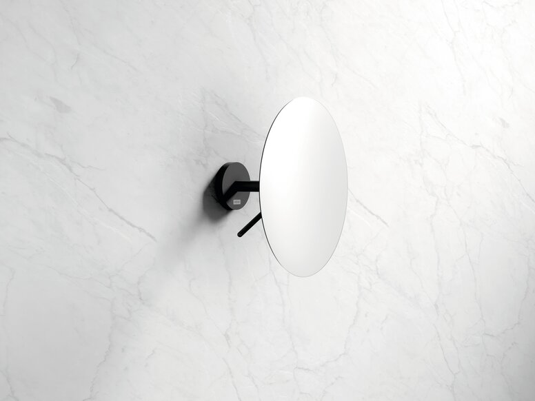 HEWI System 900 make-up mirror Wall mirror with a round mirror pane and a black holder for wall mounting against a white marble background