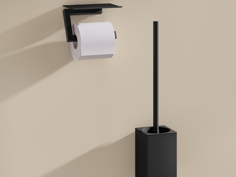 HEWI System 900Q WC-Bürstengarnitur und WC-Papierhalter Schwarzer pulverbeschichteter WC-Papierhalter mit Ablage und schwarze Toilettenbürste mit Halterung an beigefarbener Wand