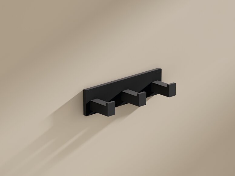 HEWI System 900Q Hakenleiste Schwarze pulverbeschichtete Garderobenleiste mit drei quadratischen Haken an beigefarbener Wand