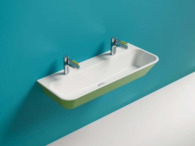 Wall-mounted double washbasin in green and white mineral composite, with two taps featuring yellow handles against a blue wall